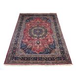 A late 20th century Persian rug, the salmon and blue medallion within matching borders,