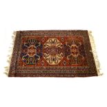A 20th century rug, the three central medallians within a red ground and matching borders,