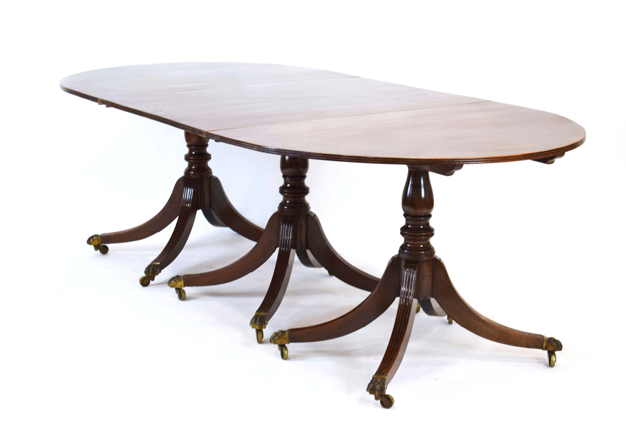 An early 20th century mahogany oval dining table on three columnar pedestals with reeded legs and - Image 6 of 12