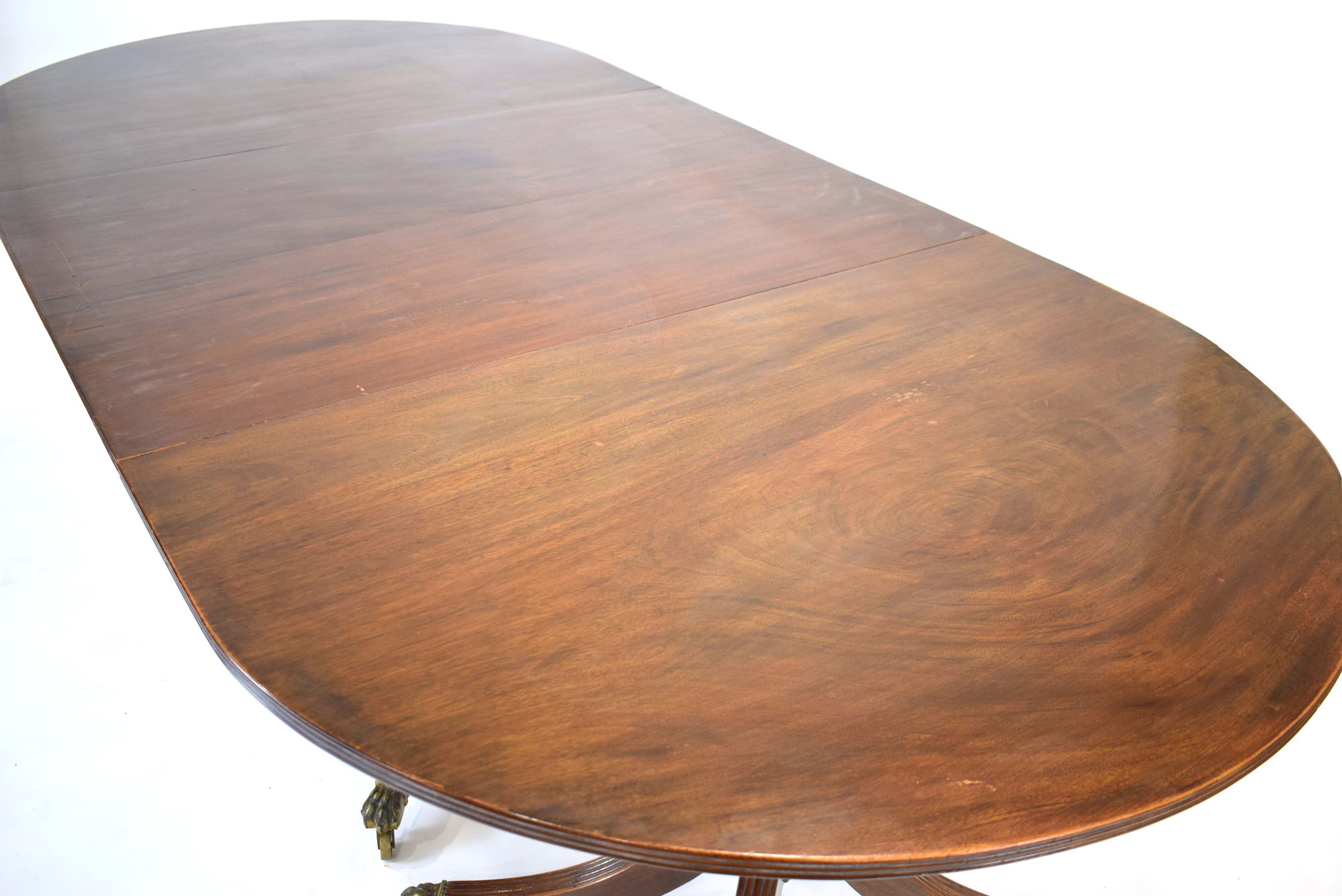 An early 20th century mahogany oval dining table on three columnar pedestals with reeded legs and - Image 3 of 12