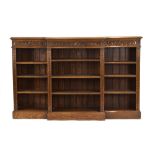 A late 19th/early 20th century carved oak breakfront bookcase with adjustable shelves on a plinth