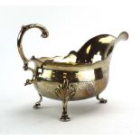 A late Victorian silver sauce boat with leaf capped c-scroll handle on three hoof feet, maker CB,