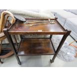 Beech two tier tea trolley plus three brass toasting forks and a wrought iron chestnut roaster