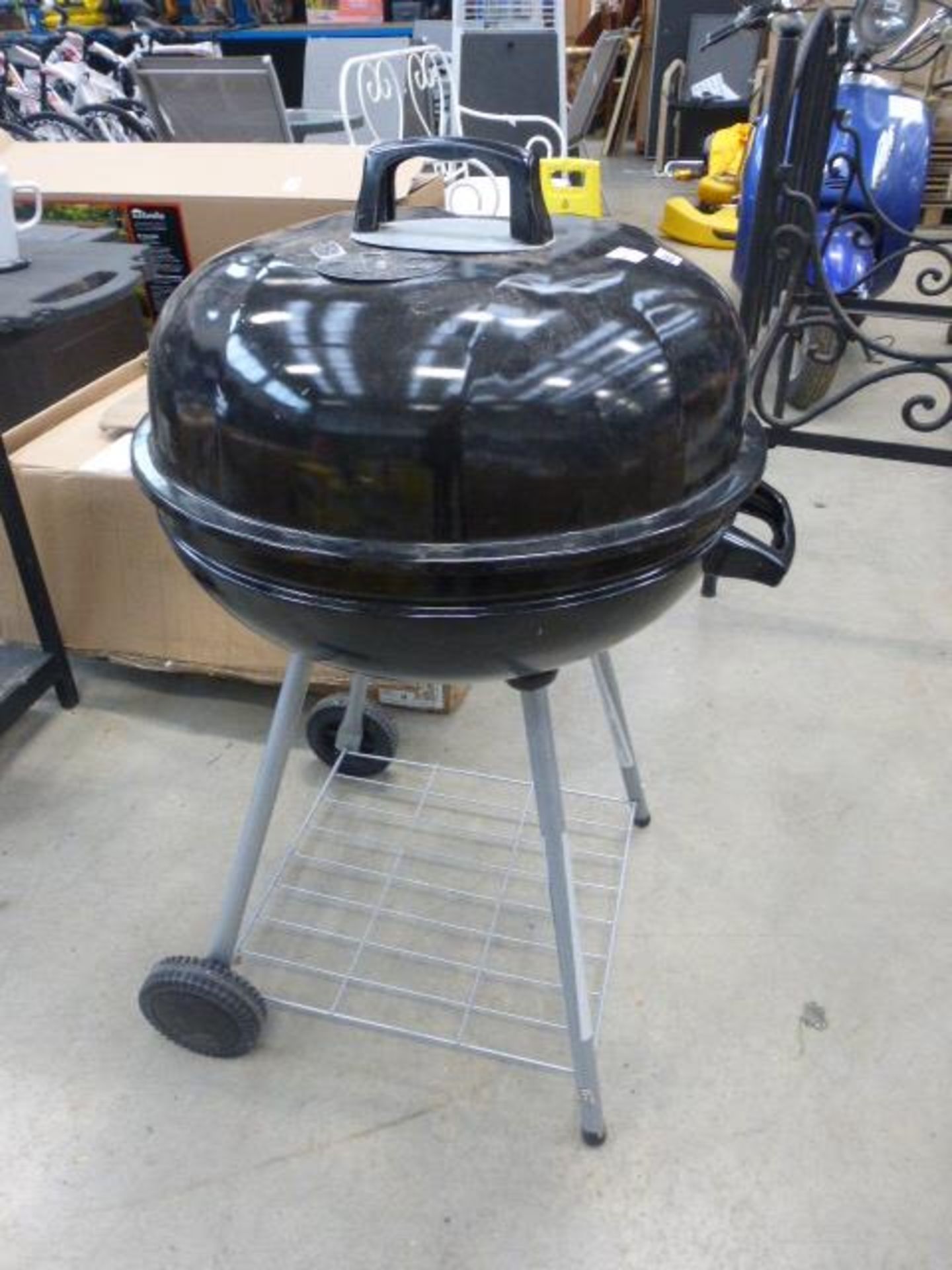 Round charcoal barbecue on stand