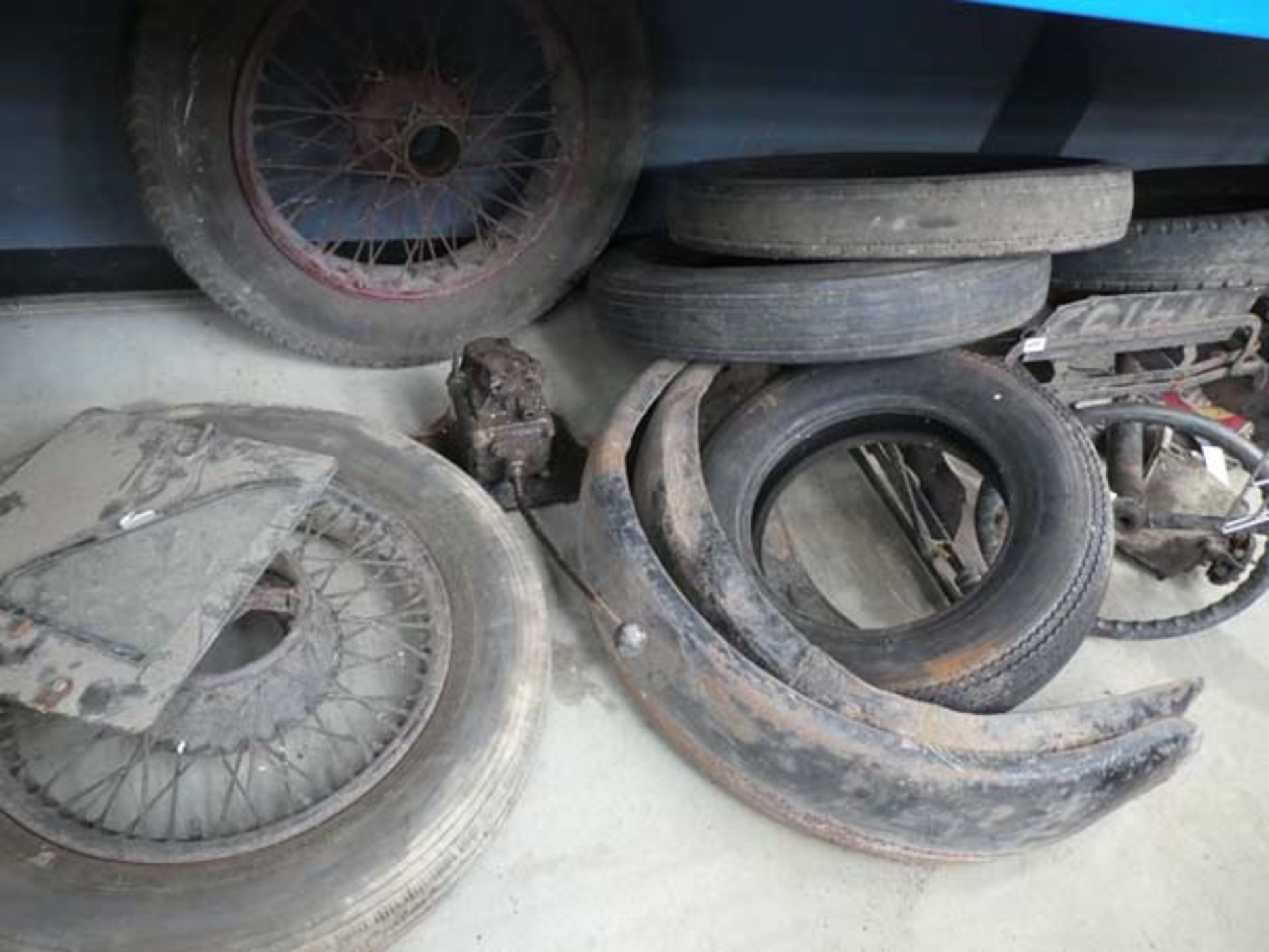 Large underbay of vintage Austin car parts to inc. spoke wheels, tyres, steering rack, part gear