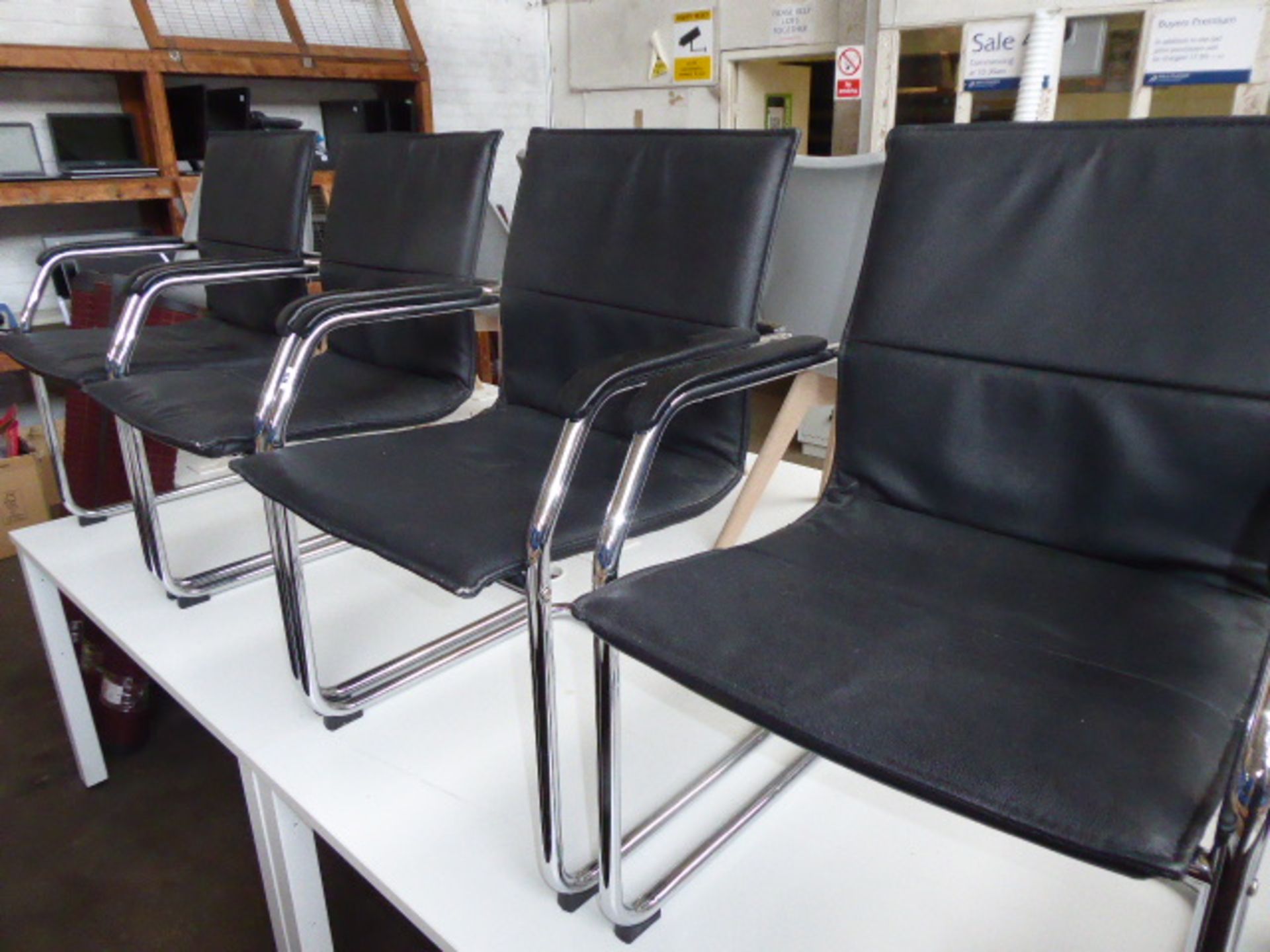 Four black leather effect and chrome frame cantilever chairs