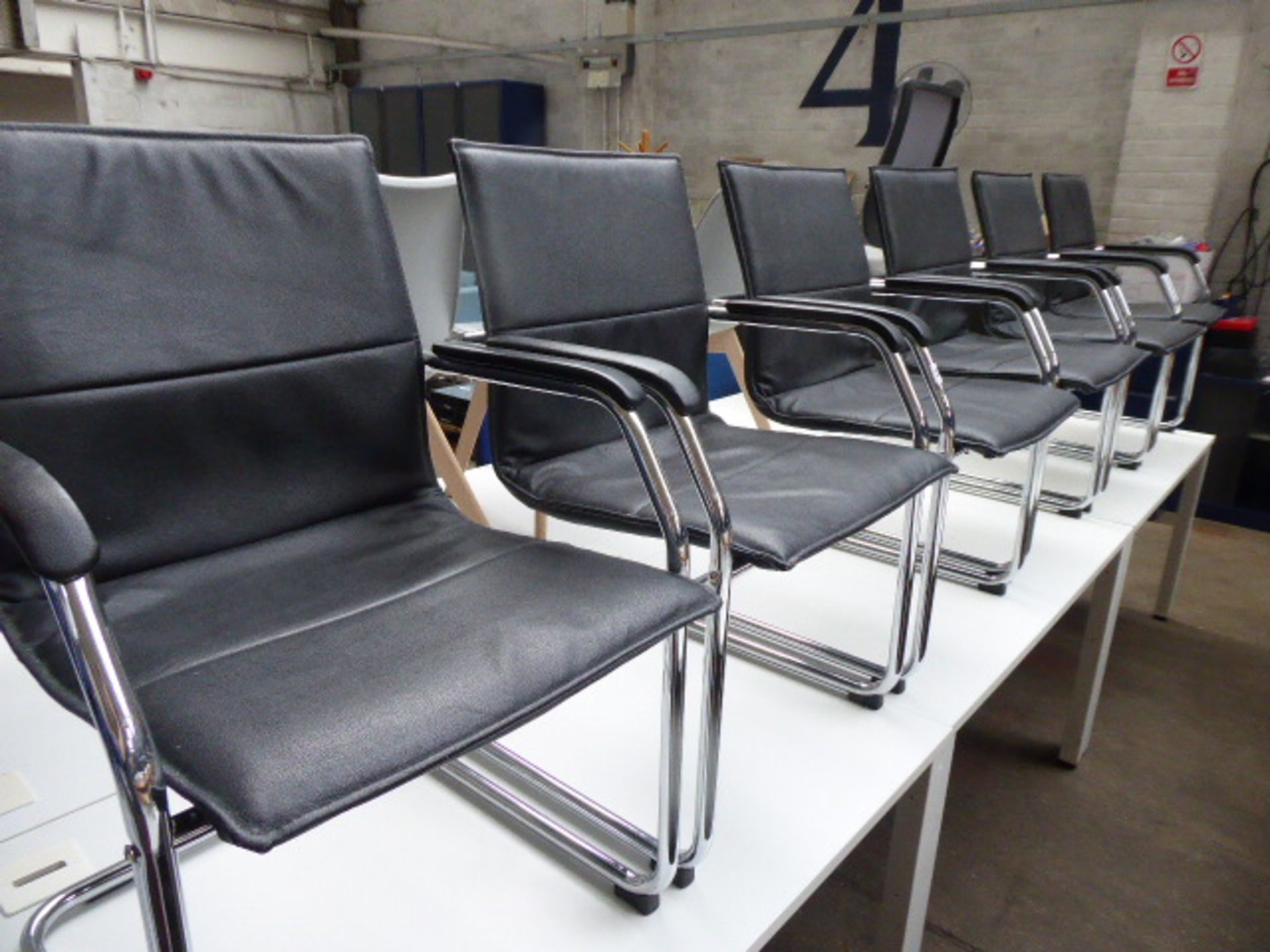 Six black leather effect and chrome frame cantilever chairs