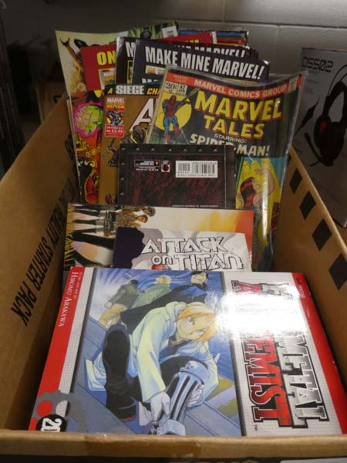 Box containing a small selection of graphic novels and Marvel comics