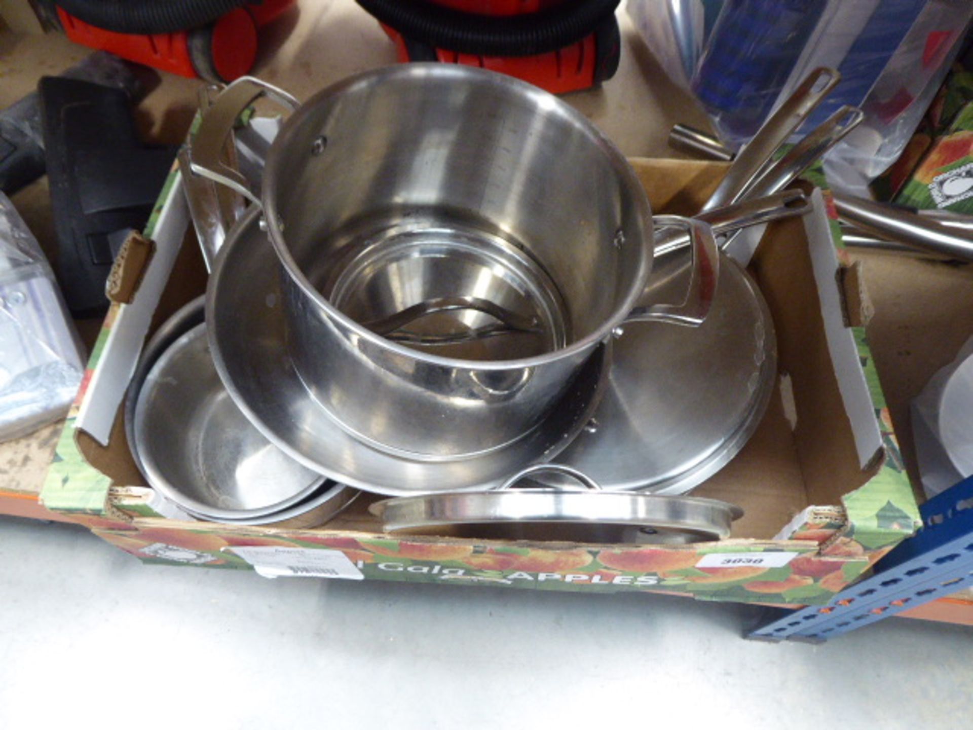 Tray containing stainless steel pots and pans, used
