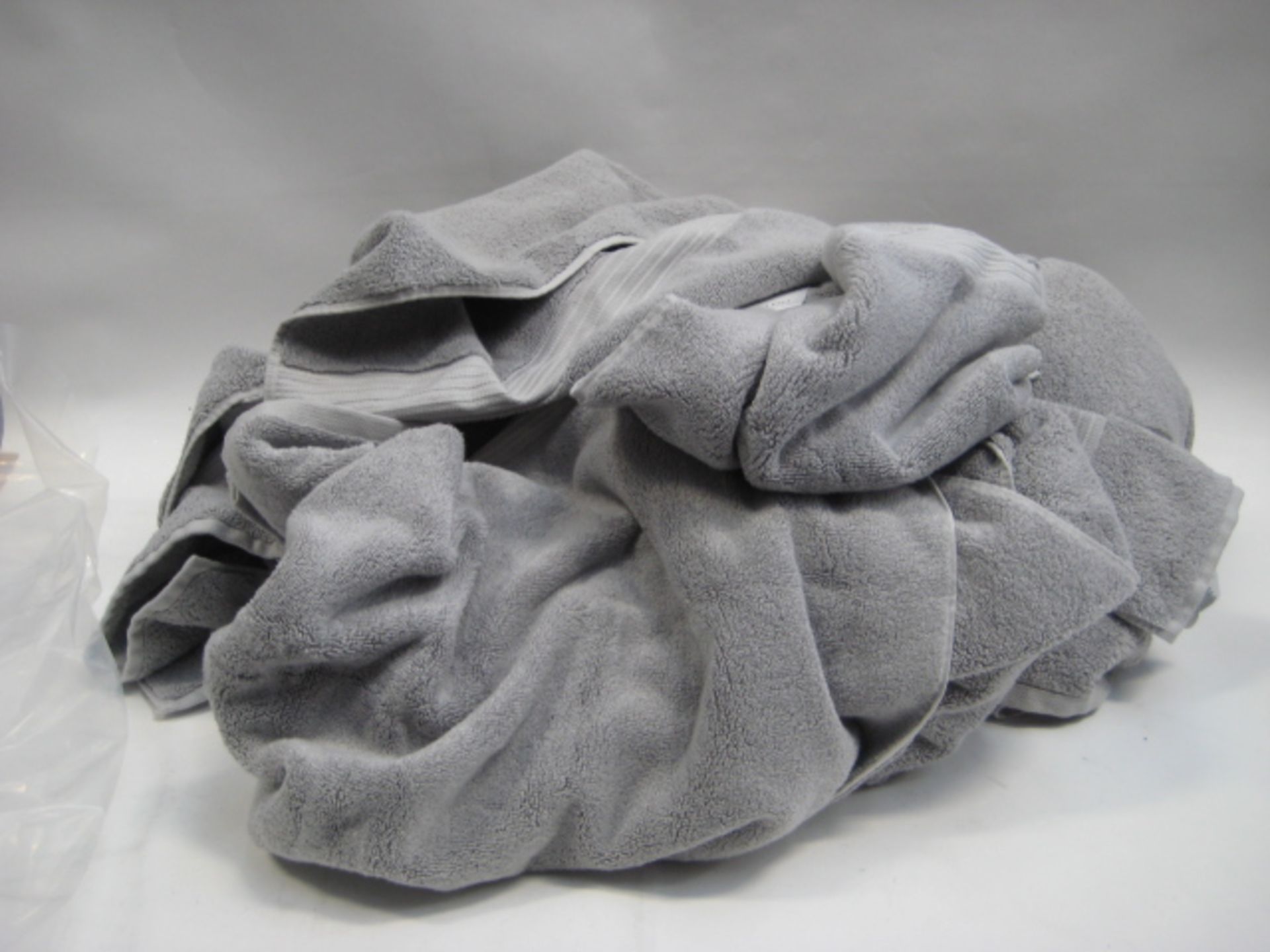 Bag containing various sized Calvin Klein grey towels, some with tags