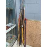 Bundle of coarse and fly fishing rods plus a wooden bow and ice hockey stick