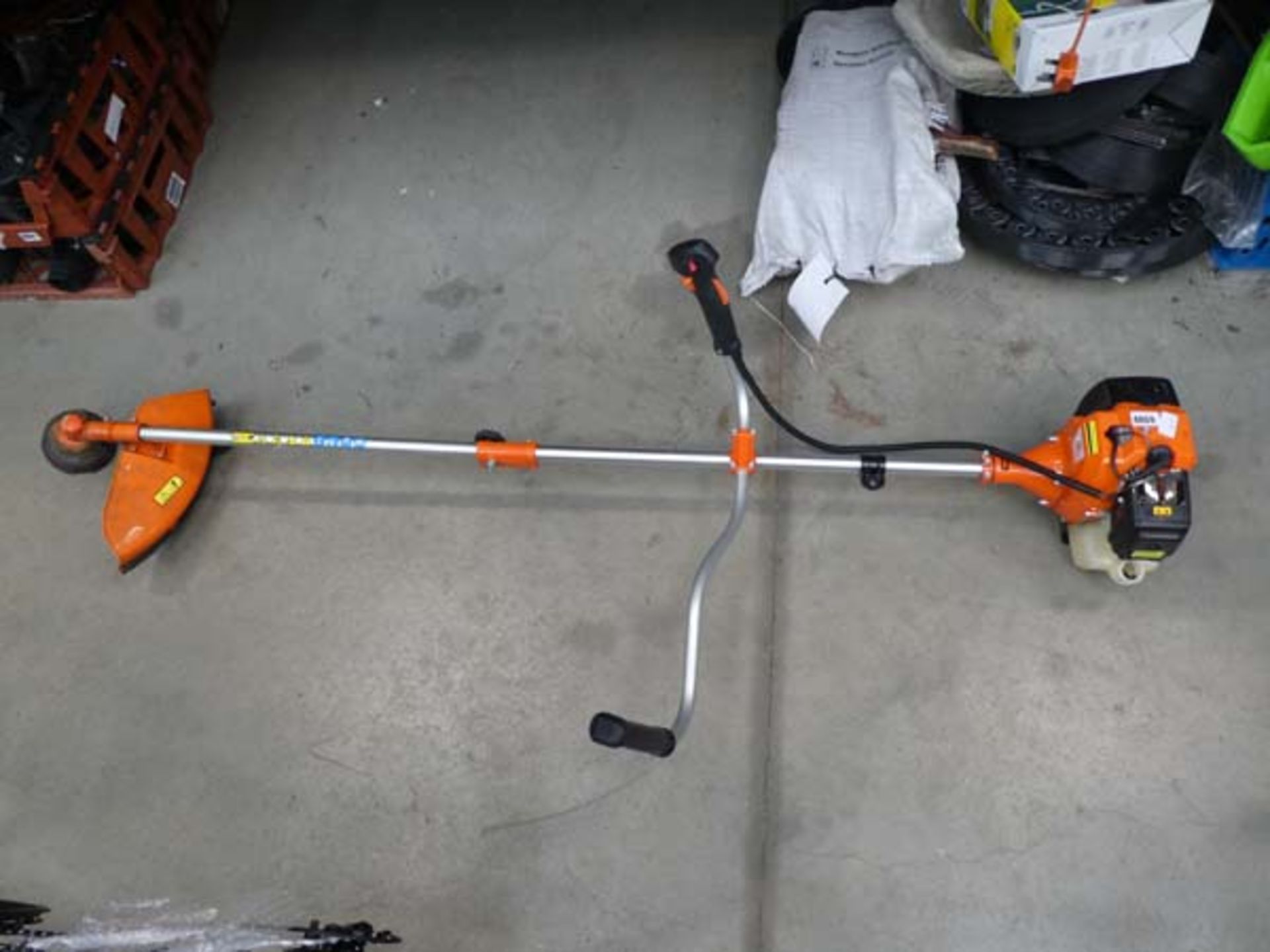 Orange petrol powered strimmer