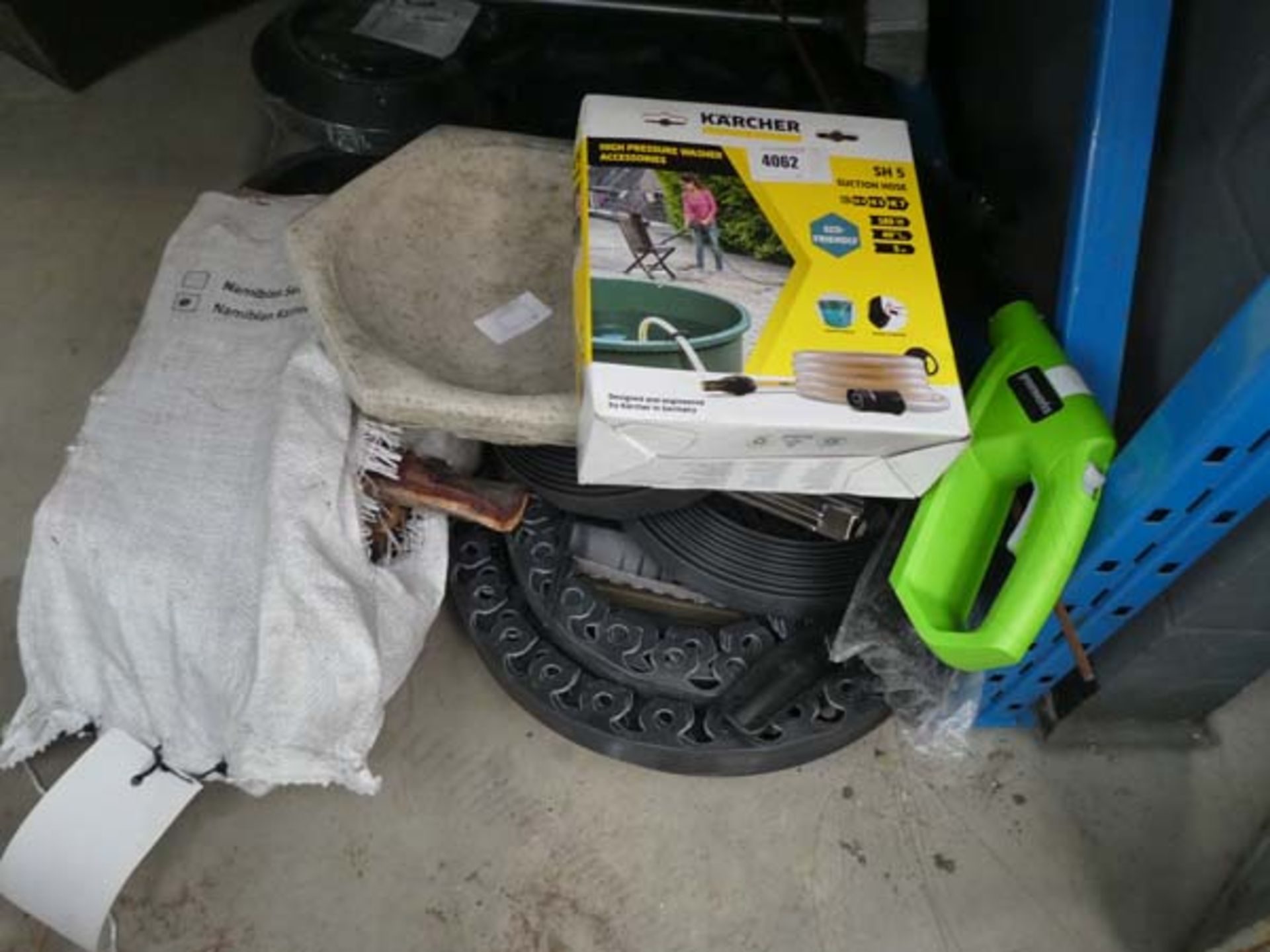 Half an underbay containing Karcher washer hose, strimmer parts, birth bath top, wood, brushes, etc