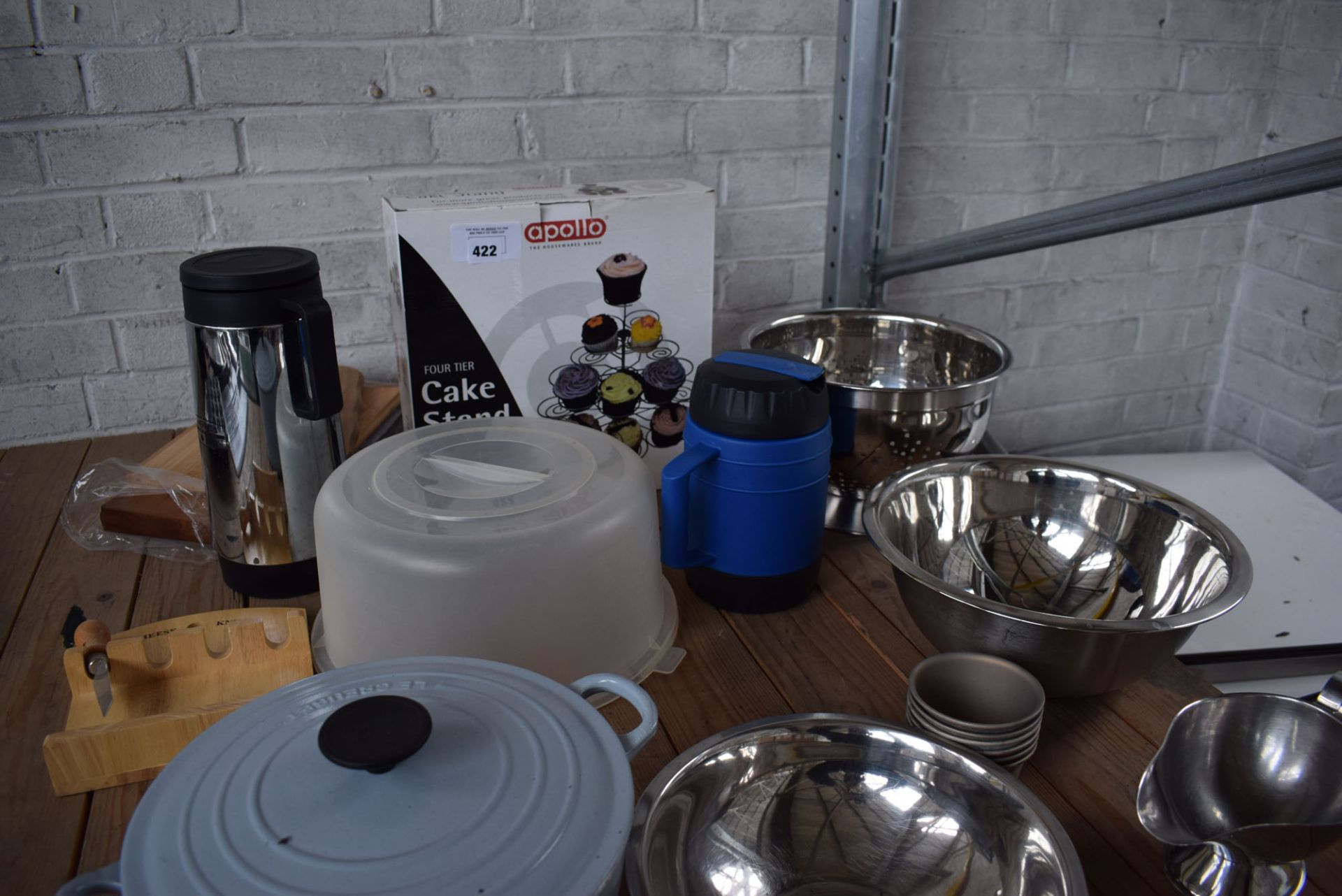 One third of a shelf of mixing bowls, sieves, gravy dishes, Le Creuset casserole dish, cake stand,