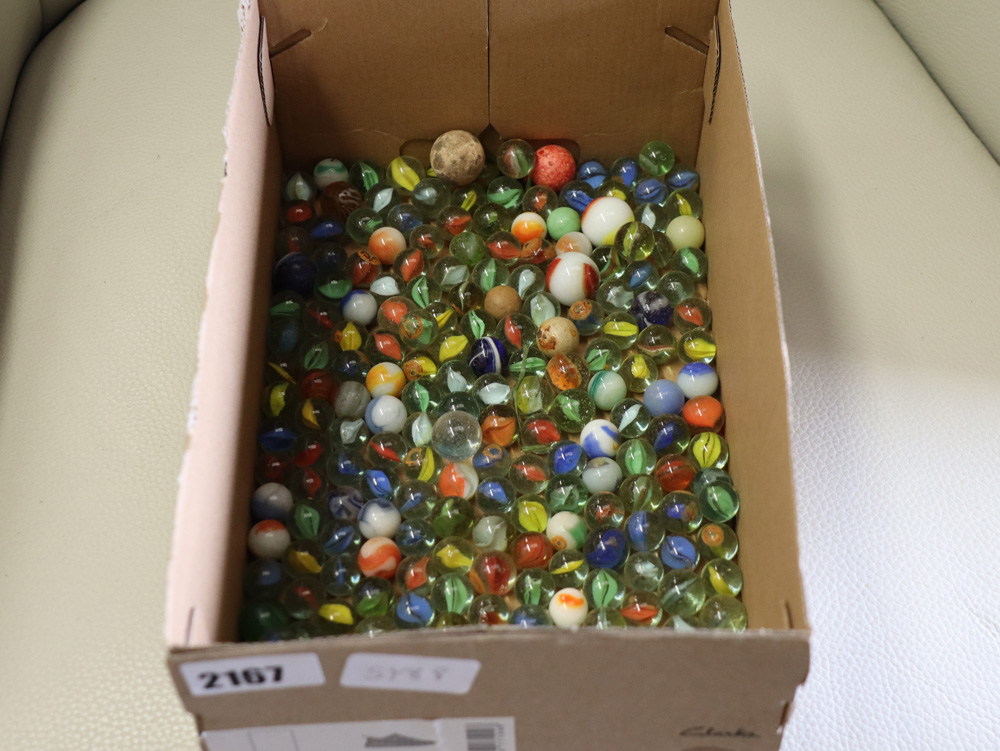 Shallow box containing various marbles