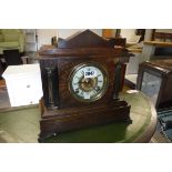 Oak cased mantle clock with decorative columns and ornate feet