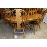 Extending dining table with radiused ends and 4 matching spindle back dining chairs