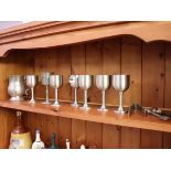 Shelf of containing pewter goblets, jug, tongs and metal spoons