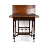 An Edwardian walnut writing desk with double-hinged lid and frieze drawer on a Canterbury-style