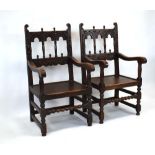 A pair of 17th century style oak Derbyshire armchairs with carved backs and bobbin stretchers