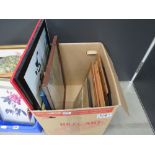 Box containing Japanese prints, modern print with bottle tops, racing driver, picture frames and