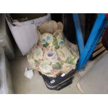 Suitcase with quantity of handbags and floral lampshade