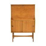A 1960's British teak bureau, the fall front enclosing a fitted interior, over two sliding doors, w.