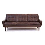 A 1960/70's Danish brown leather and button upholstered three-seater sofa on tapering legs,