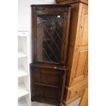 Dark oak corner display cabinet with leaded glass door