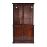 A Regency mahogany bookcase cabinet, the pair of glazed doors enclosing three shelves,