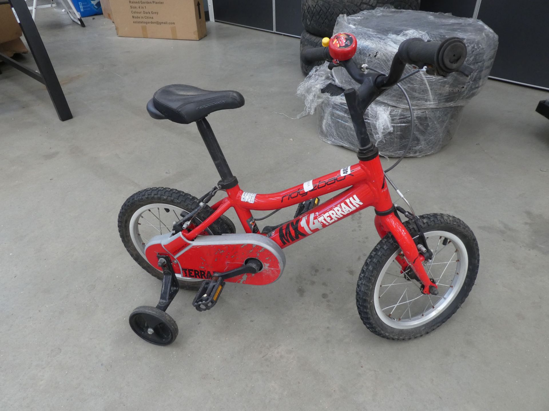 Small childs red Ridgeback bike with stabilisers