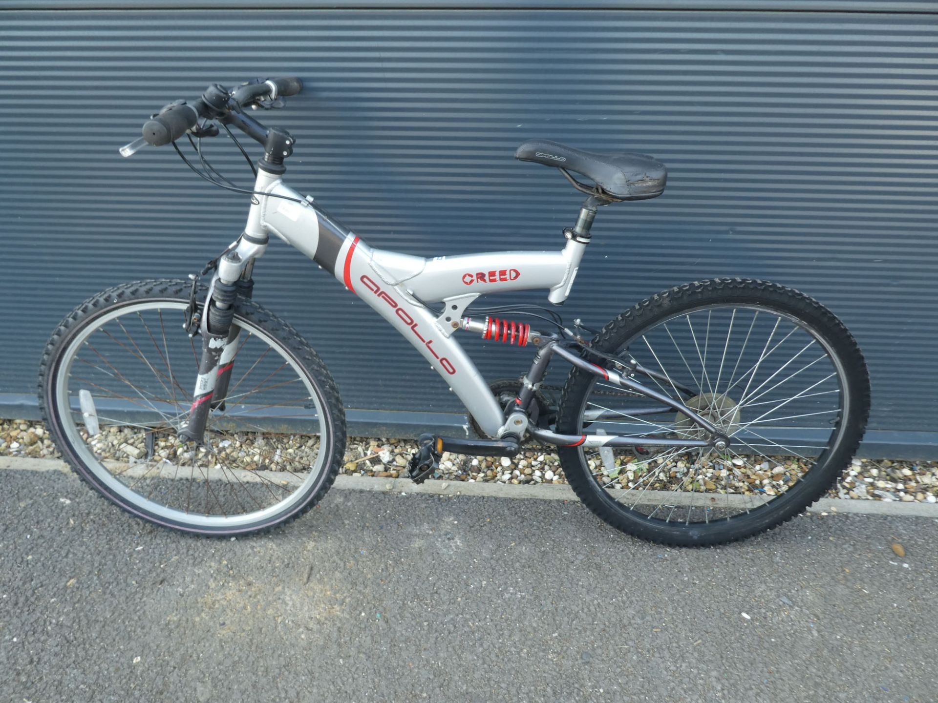 Silver and red Apollo suspension mountain bike