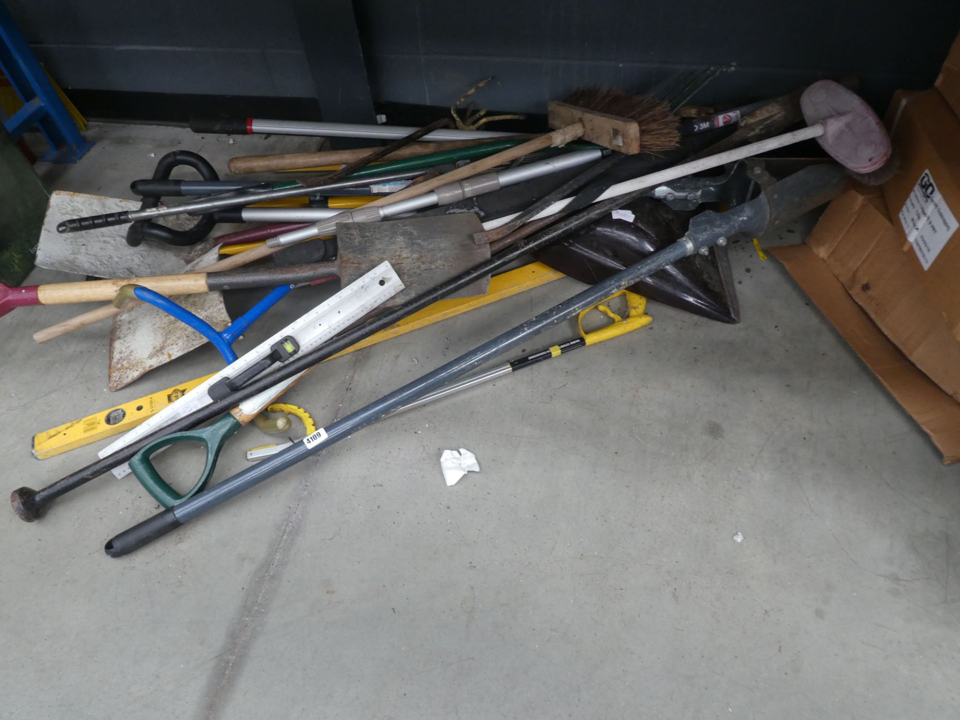 Large under bay of assorted tools inc. post hole digger, wash brush, crow bars, spade, shovels etc