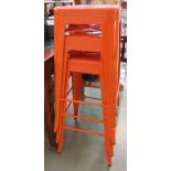 3 orange painted metal stacking stools
