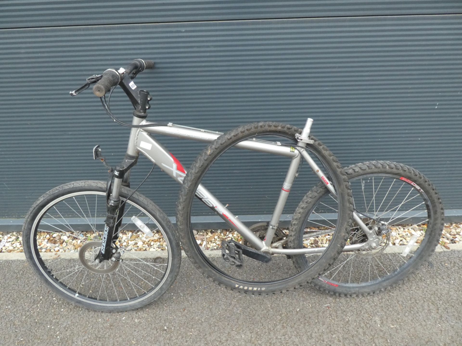 Apollo mountain bike in silver and red with spare wheel and no saddle