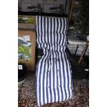 Green metal framed sun lounger with blue and white striped cushion