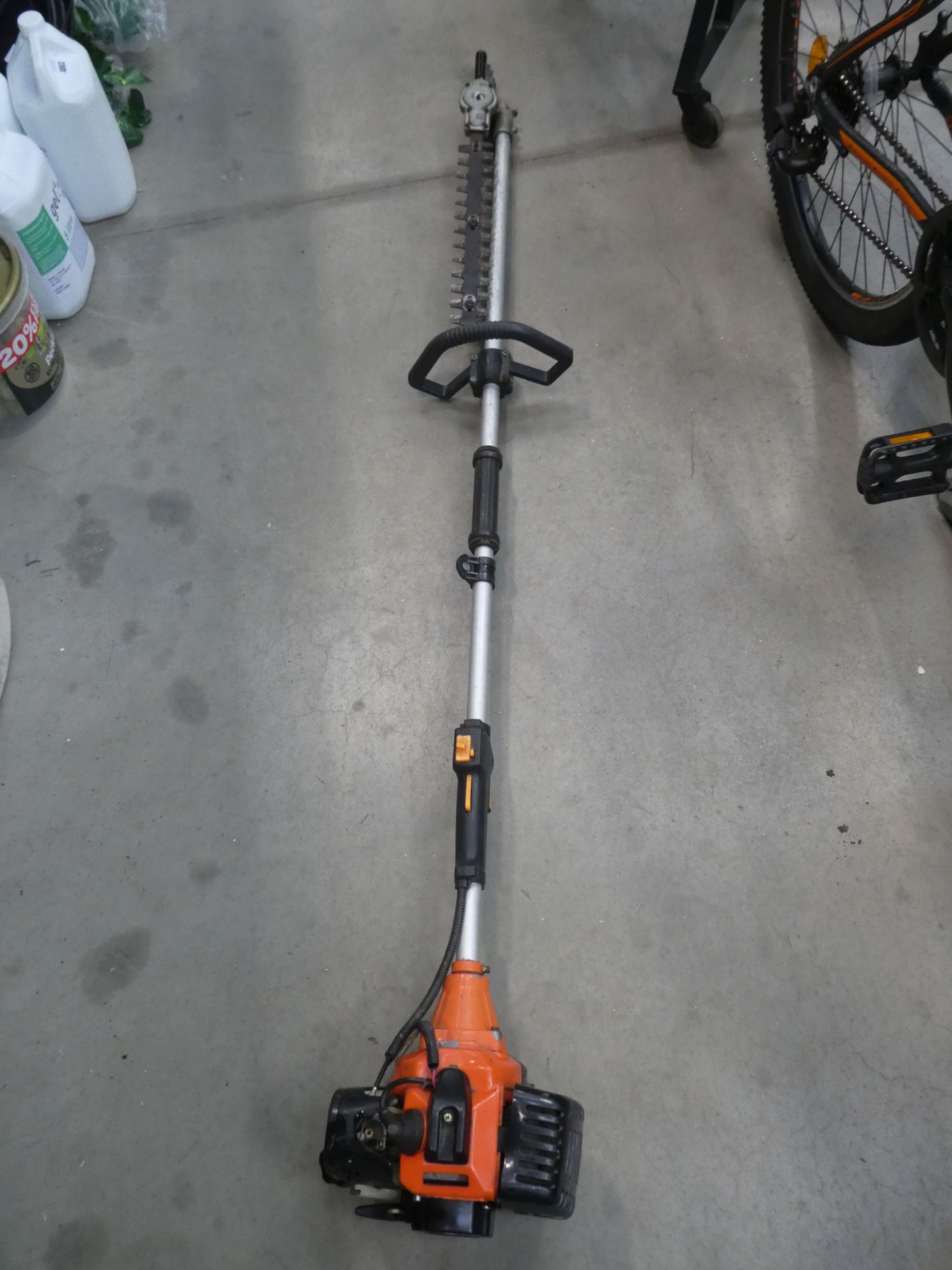 Orange petrol powered long reach hedge cutter