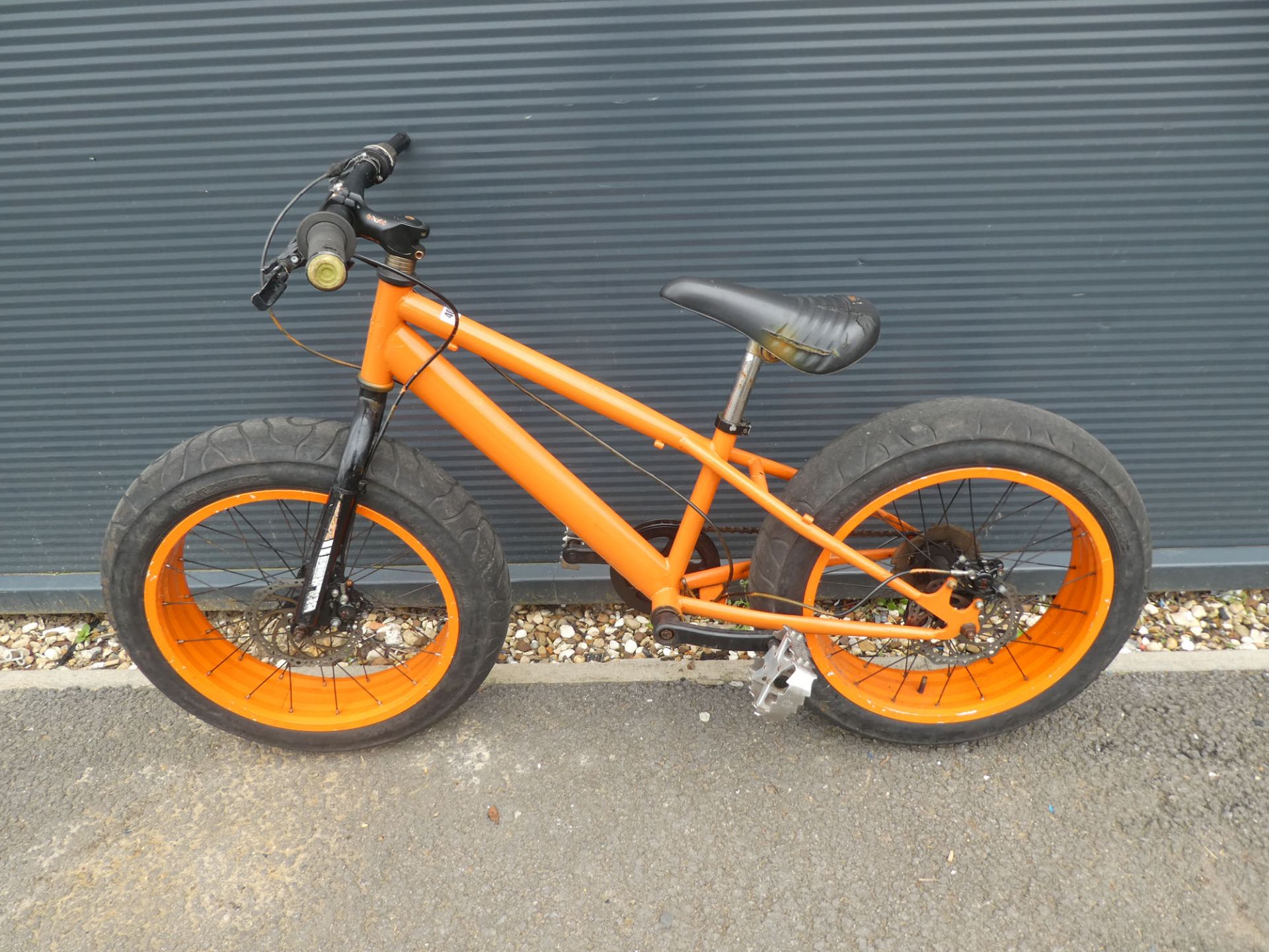 Large wheeled orange childs bike