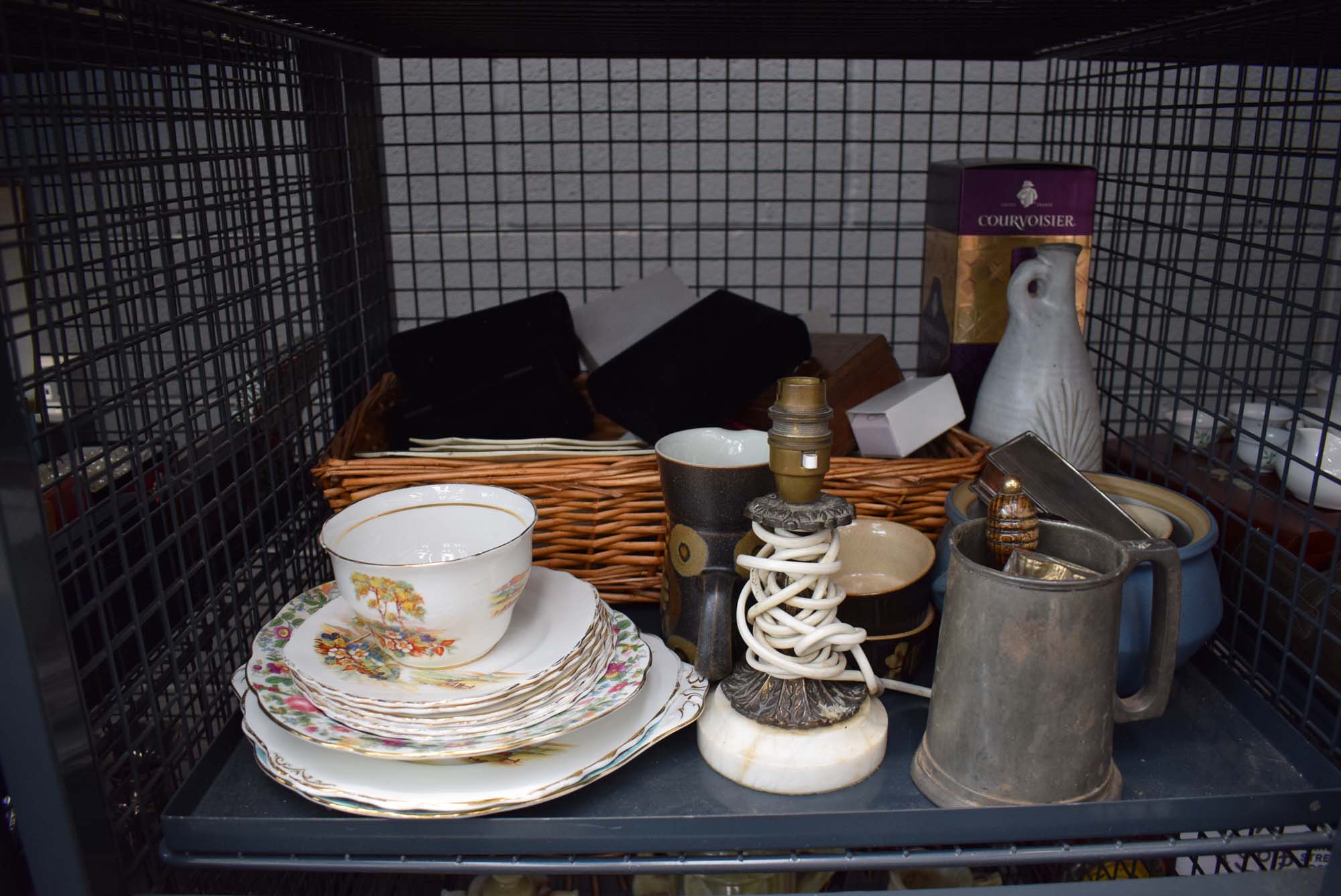 Cage containing a wicker basket, general crockery, table lamp and a pewter mug