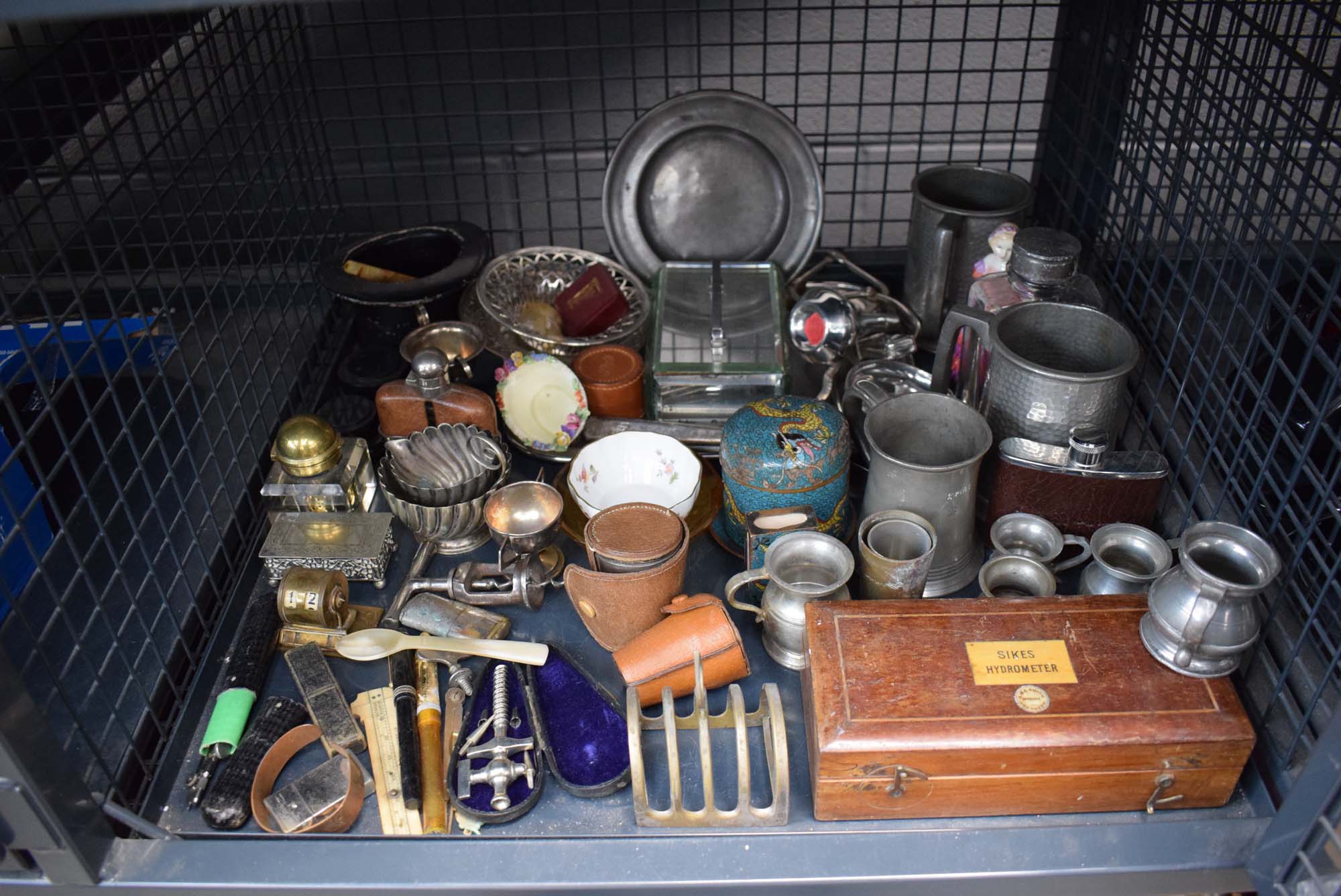 Cage containing pewter ale mugs, silver plated jugs, hip flask, tray, toast rack and trinkets