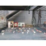Cage containing ornamental lead farm yard animals, miniature microscope, tins and slate pictures
