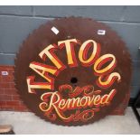Painted ''Tattoos Removed'' sign on circular saw blade