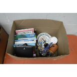 (2319) Crate containing ceramic clock, cyclist ornament, storage jar, diary and books