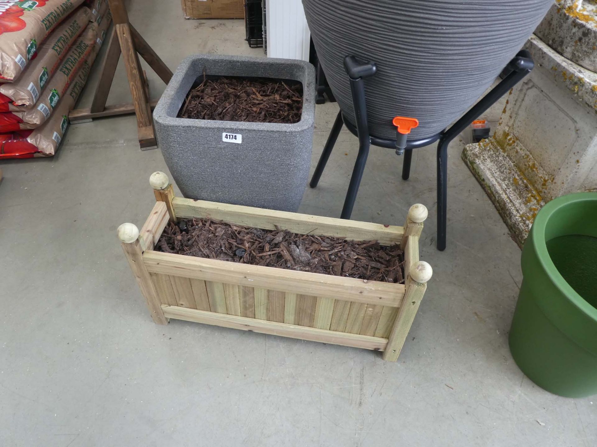 Plastic stone effect pot and a small wooden trough