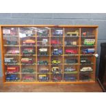 Quantity of die cast delivery vans, buses and cars in a display case