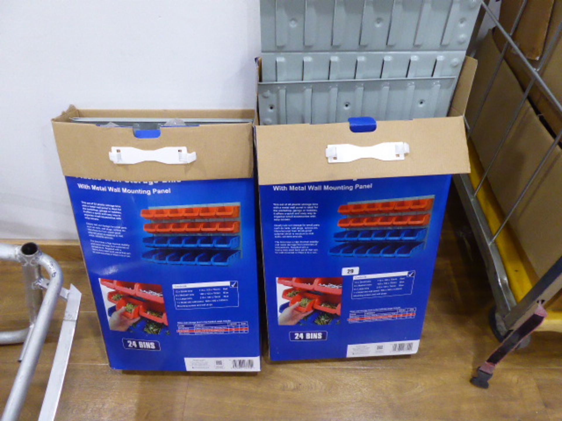 2 boxes containing metal wall racks with plastic bins