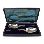 A cased pair of (?)Dutch metalware apostle serving spoons, maker MG, l. 19 cm, 3.