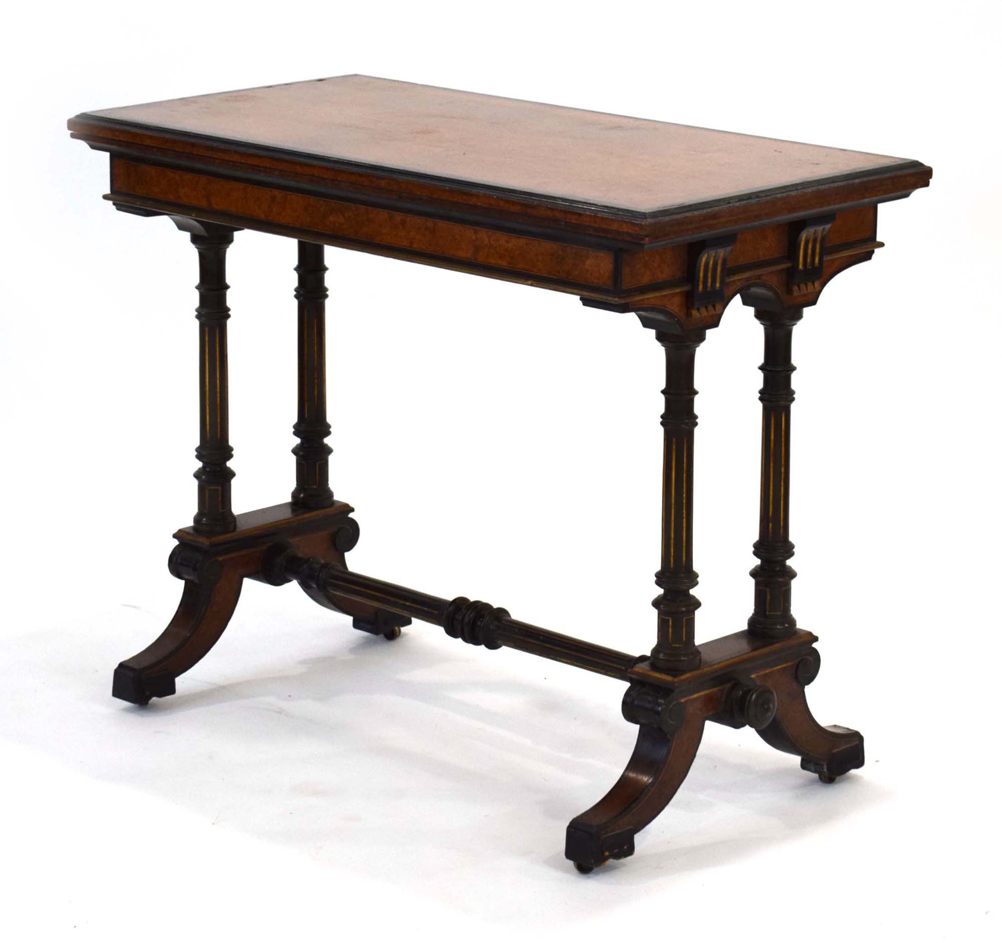 A Gillows side table, the walnut and ebonised top folding to reveal a baize covered games surface,