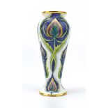 A miniature Moorcroft enamelled vase of baluster form decorated with stylised flowers on a white