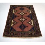 A Caucasian rug, the salmon ground with four medallians within a red and green foliate border,